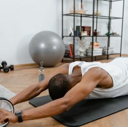 A man performs an ab roller workout indoors, emphasizing healthy lifestyle and fitness. — 9 Online Fitness Equipment Retailer