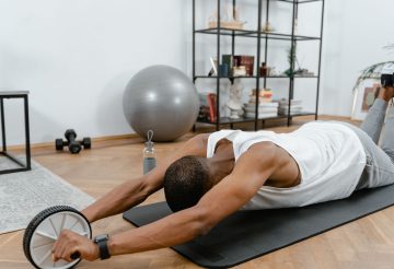 A man performs an ab roller workout indoors, emphasizing healthy lifestyle and fitness. — 9 Online Fitness Equipment Retailer