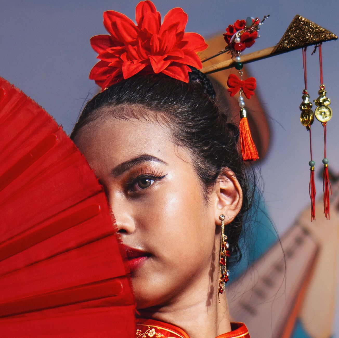 Close-up of a woman in traditional Chinese dress with red fan and hair ornaments. — Eco Skincare - Is it Ethical to Use Beesw
