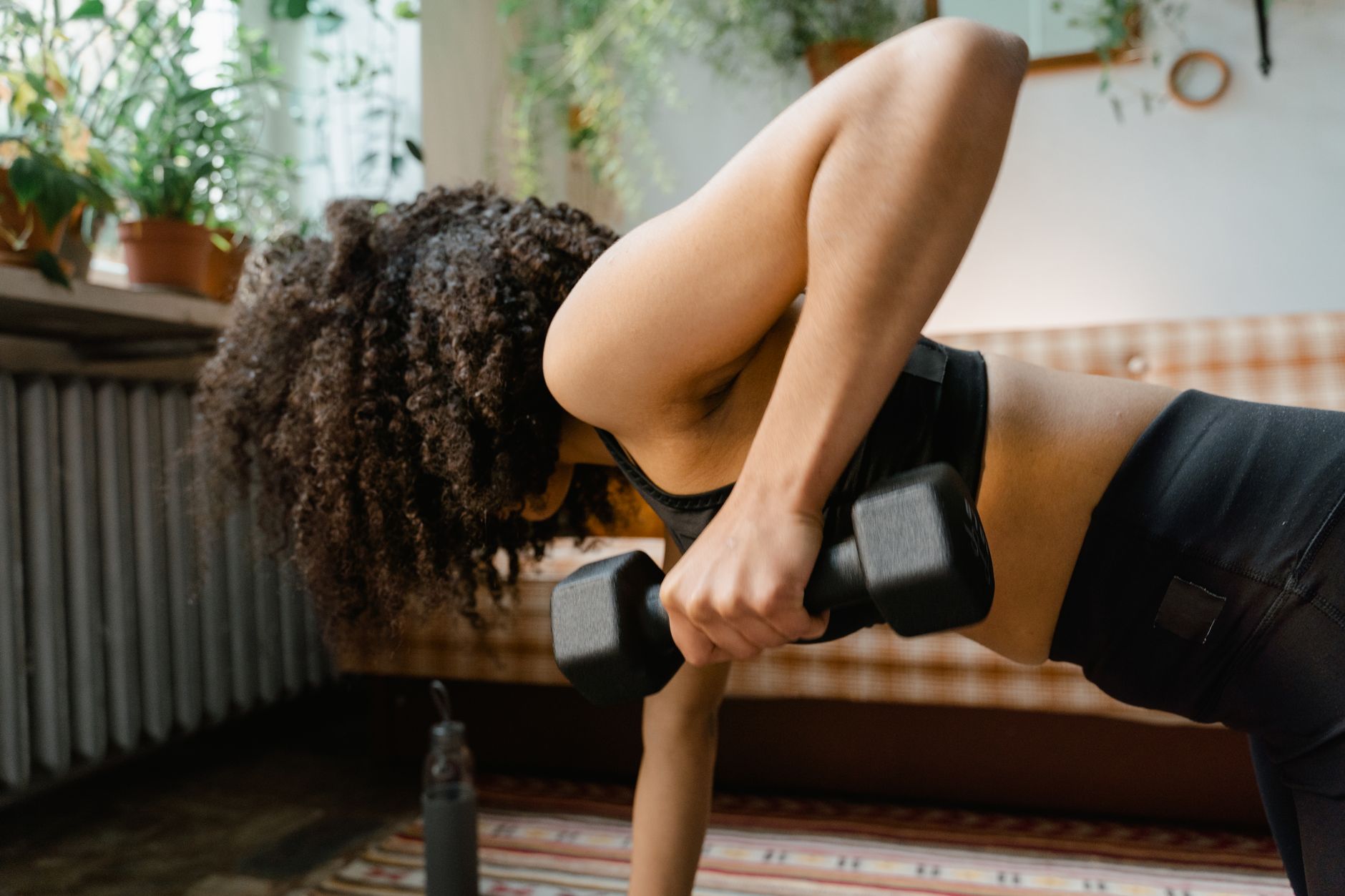 African American woman working out with dumbbells in an indoor setting, promoting a healthy lifestyle. — How To Get Fit - Get