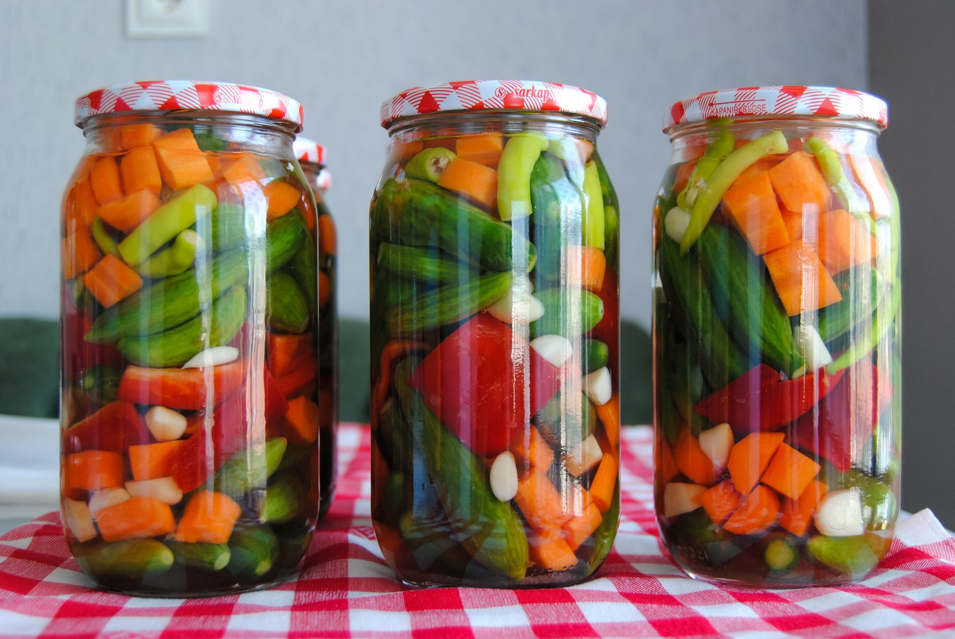 Three jars of assorted pickled vegetables on a red checkered tablecloth. — Keys to Creating a Successful Diet Food Plan