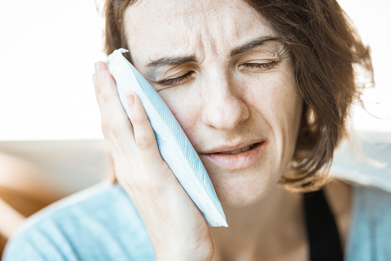 Girl, ice pack, toothache — What is invisalign in Birmingham?